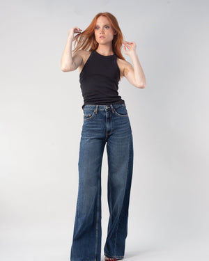 woman with red hair wearing the 90s tank in black with jeans