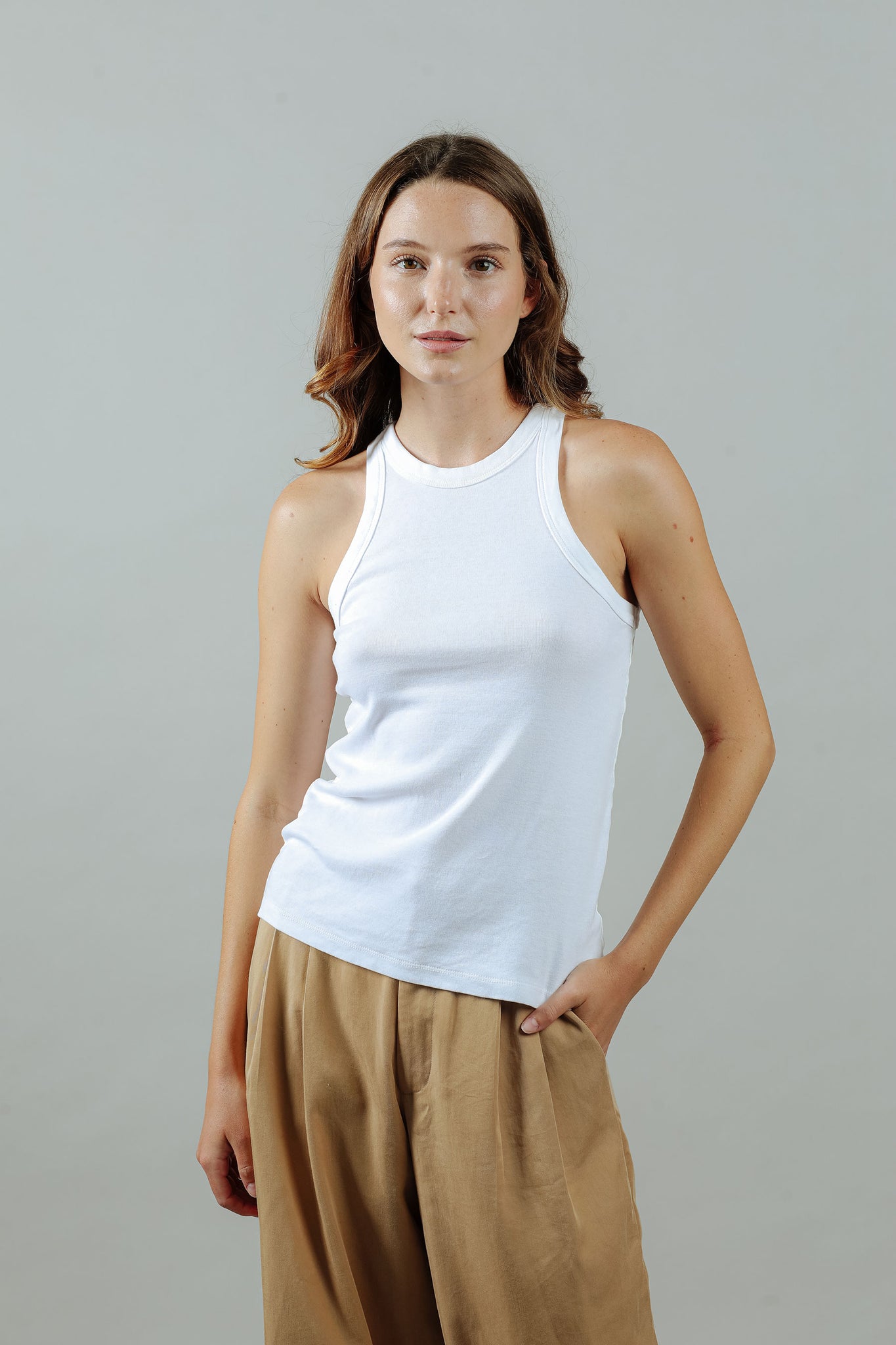 woman wearing the 90s tank in white from the front untucked